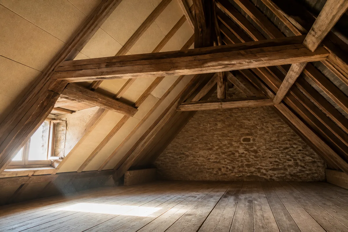 Comble ancien avec charpente apparente en bois et panneaux de fibre de bois posés entre les chevrons