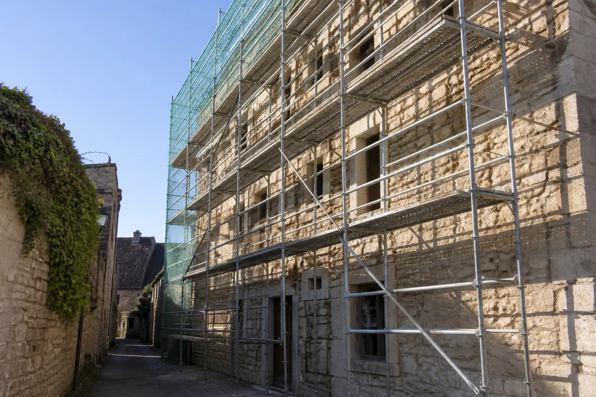 Façade en pierre calcaire d&rsquo;une maison provençale avec échafaudage installé pour un chantier de rejointoiement